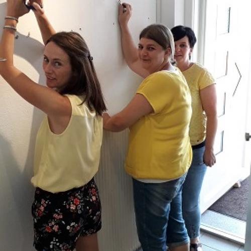 Drei Frauen entferne Haken und Nägel von der Wand