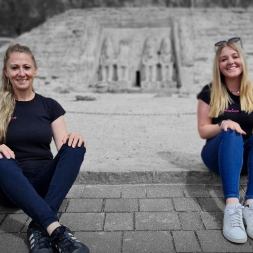 Zwei Frauen sitzen vor Abu Simbel. Die Personen sind in Farbe, der Hintergrund  in schwarz-weiß