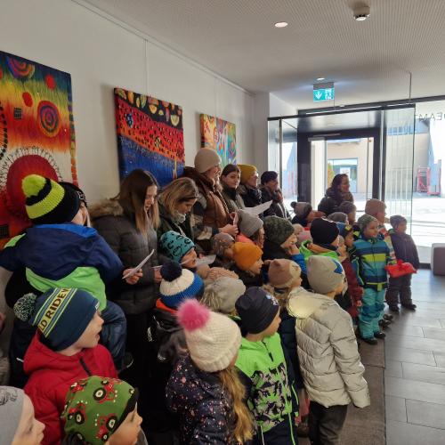 Pädagogen und Kinder stehen in Reih und Glied und singen Josef ein Pensionslied