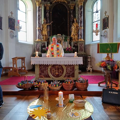 Ein Legebild der Kinder vor dem Altar mit einer schönen Kerze