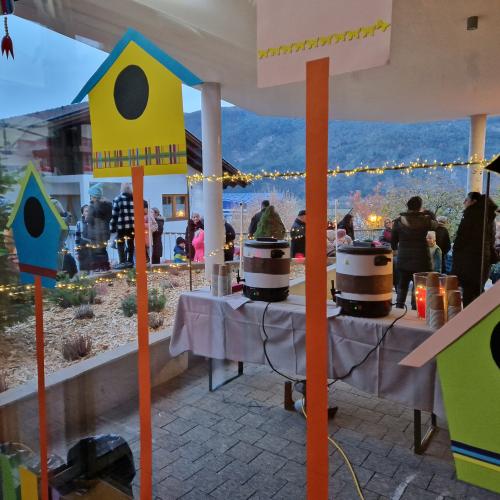 Ein Blick durch das große Fenster des Kindergartens. Das Buffet steht bereit und einige Menschen sind schon eingetroffen