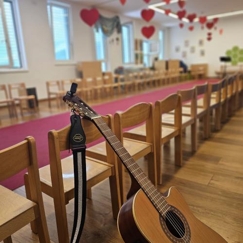 Die Gitarre lehnt an der Stuhlreihe neben dem Catwalk