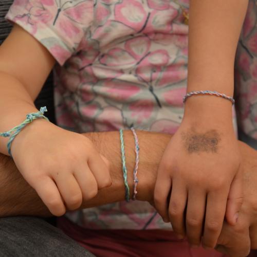 Eine Hand des Vaters und Hände seiner Kinder