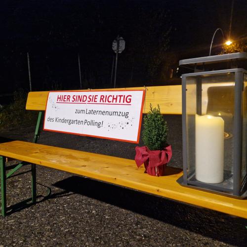 Begrüßungsschild auf der Bank, welche die Straße für unser Fest absperrt. Eine gr. Laterne und ein kleines Bäumchen stehen als Deko daneben