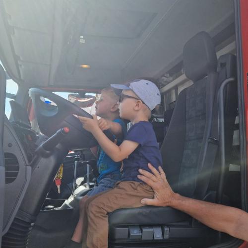 Zwei Kinder sitzen im Feuerwehrauto