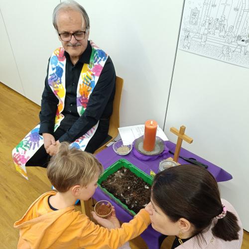 Ein Kind streut Kressesamen in die Erde