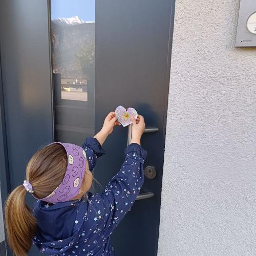 Ein Kind hängt ein Herz an die Tür