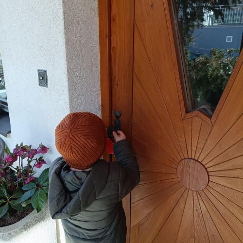 Ein Kind hängt ein Herz an die Tür