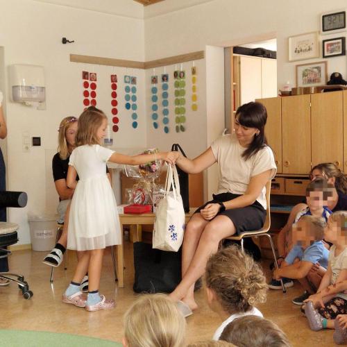 Ein Kind überreicht Ruziye die von den Kindern gestaltete Tasche zum Abschied
