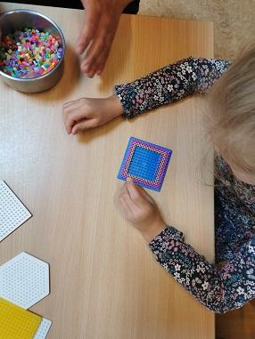 © cc Ein Kind spielt mit den Bügelperlen