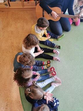Kinder sitzen im Kreis und singen