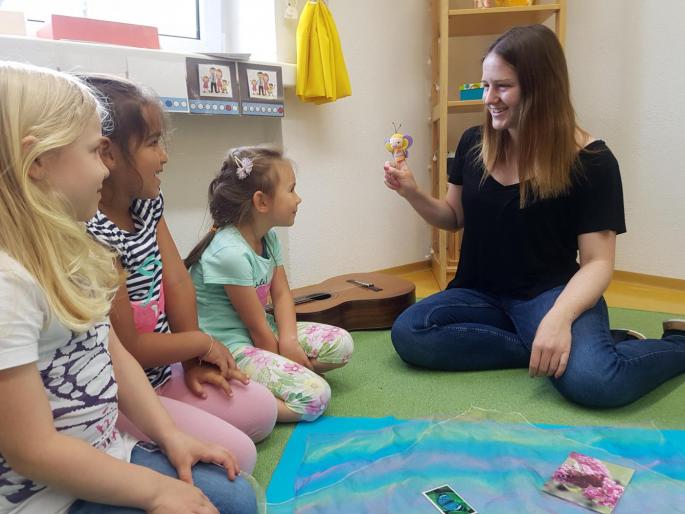 © cc Pädagogin der Schmetterlingsgruppe spielt mit einer Schmetterlings-Fingerpuppe