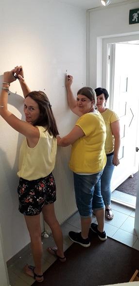 Drei Frauen entferne Haken und Nägel von der Wand