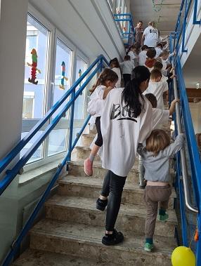 Die Kinder gehen verkleidet die Schulstiege hinauf um die Schüler zu erschrecken