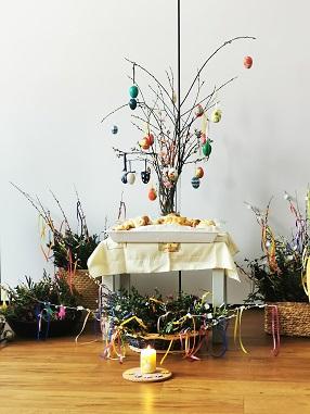 © cc Ein mit bunten Ostereier geschmückter Palmbusch steht auf dem Altar. Daneben befinden sich die vielen kl. Palmbuschen der Kinder zum Segnen