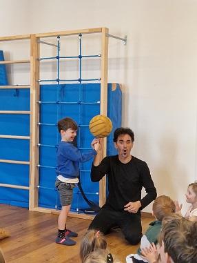 © cc Der Zirkusartist lässt den Ball am Finger eines Kindes drehen