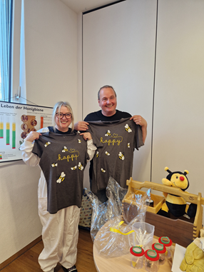© cc Das Imkerpaar Schweigl zeigt ihre geschenkten T-Shirts mit dem Aufdruck: bee happy