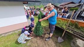 Die Kinder helfen beim einpflanzen des Baumes