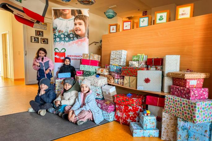 5 Kinder vor den gespendeten Geschenke für die Weihnachtspackerlaktion