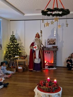 Der hl. Nikolaus steht in unserem Bewegungsraum, hält seinem Stab und sein goldenes Buch und begrüßt die Kinder