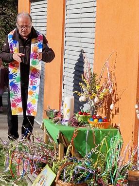 Der Pfarrer segnet im Garten die Palmbuschen und die Ostereier