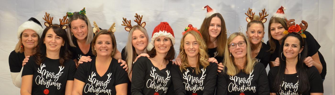 Team  des Kindergartens mit Weihnachtskleidung und Kopfbedeckung