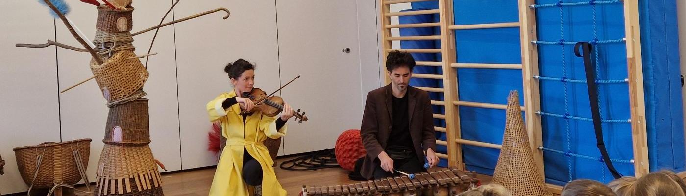 © cc Zwei Mitarbeiter des Landestheaters beim musizieren vor den Kindern