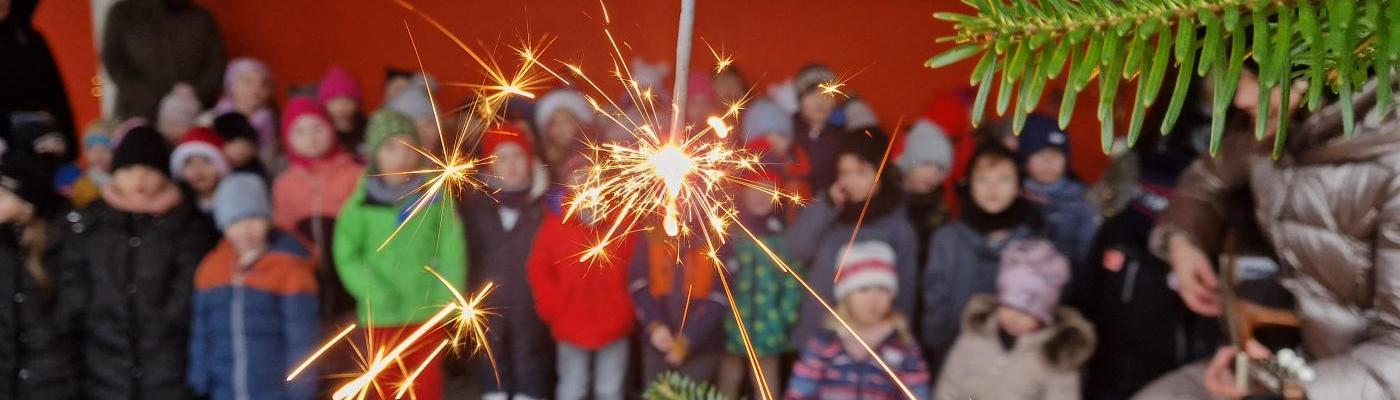 Die Funken des Sternspritzers im Vordergrund, unscharf erkennt man die Kinder im Hintergrund