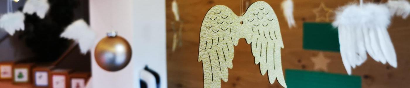 Weihnachtliche hängende Dekoration aus Kugeln und Engelsflügeln mit einer Lichterkette