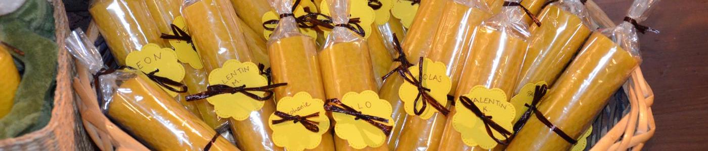 Ein Korb gefüllt mit vielen Bienenwachskerzen