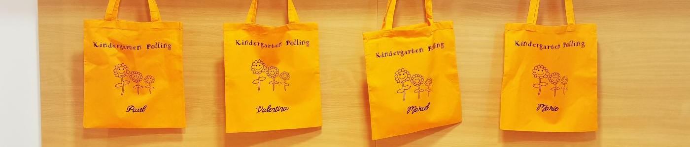 Orange Stoffsäcke mit dem Aufdruck "Kindergarten Polling" Blumen und den Namen des Kindes