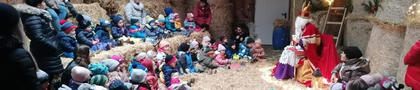 Der Nikolaus im Stall sitzend mit allen Kindern des Kinderagrtens