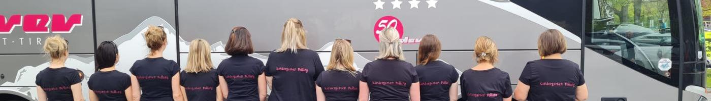 10 Teammitglieder stehen mit dem Gesicht zum Bus damit man die bedruckten T-Shirts (Kindergarten Polling) gut lesen kann mit dem Rücke