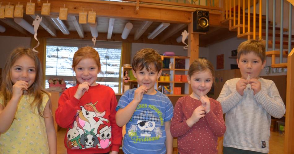 fünf Kinder haben den Lollipop Test im Mund und lächeln