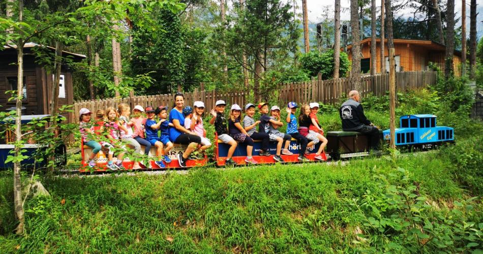Kinder auf der Mini Dampf sitzend und winkend