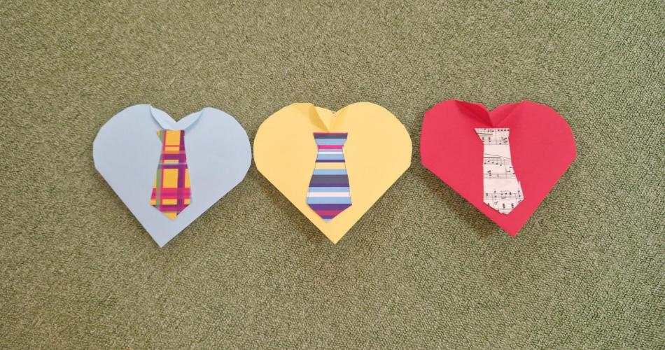 Drei Karten in Herzform als Hemd mit Kragen gefaltet und bunter Krawatte
