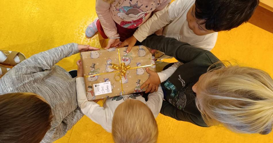5 Kinder tragen ein Geschenk , welches sie zuvor für arme Kinder in der Gruppe  eingepackt haben