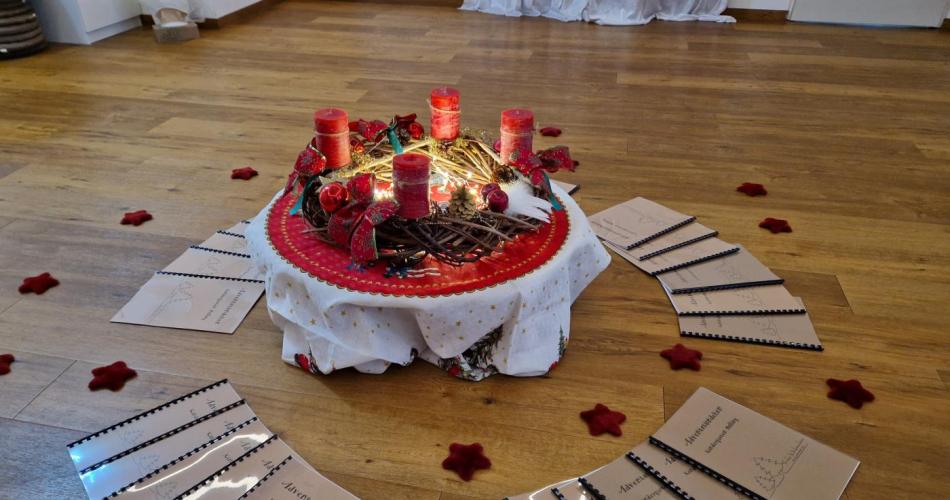 Der Adventkranz  ,die Singbüchern und die Stoffsterne liegen rund um den Kranz zur Entnahme