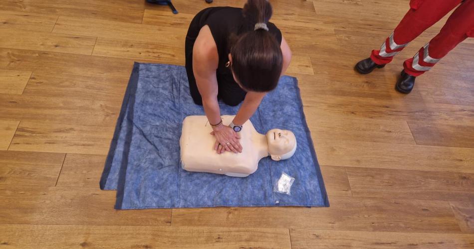 Eine Frau macht eine Herzdruckmassage an der dafür vorgesehenen Puppe im Rot-Kreuz-Kurs