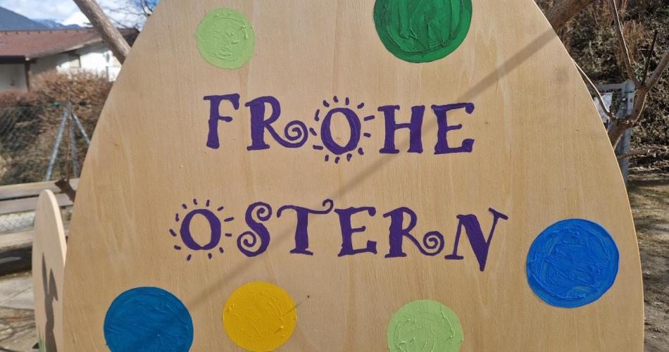 ein großes Holzei mit der Aufschrift "Frohe Ostern"