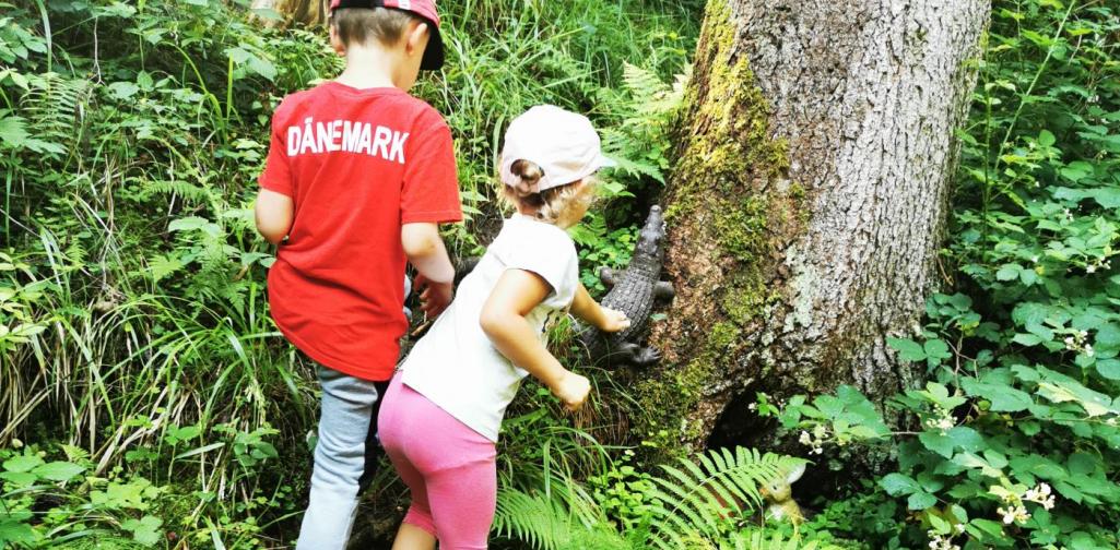 Verena Zwei Kinder betrachten ein Deko-Krokodil