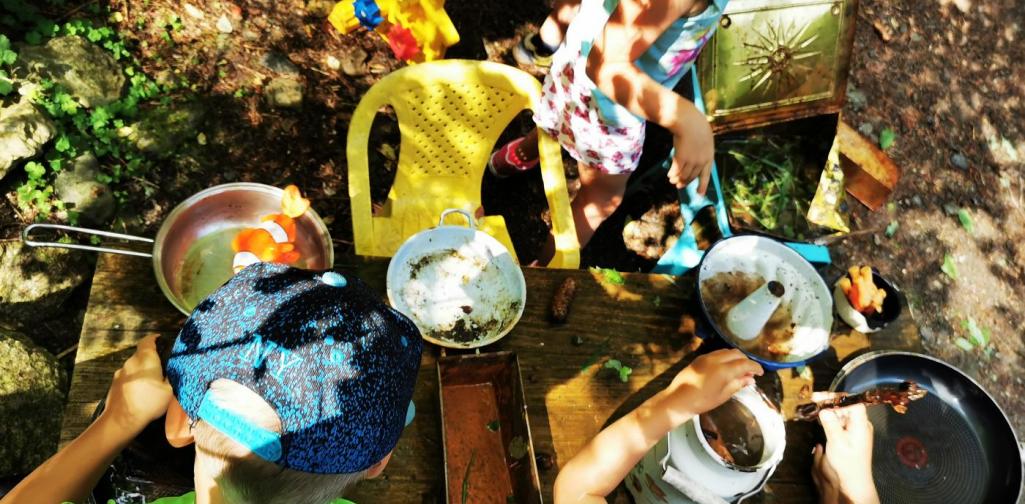 Verena Kinder beim Kochen mit Wasser und Blätter im Wald