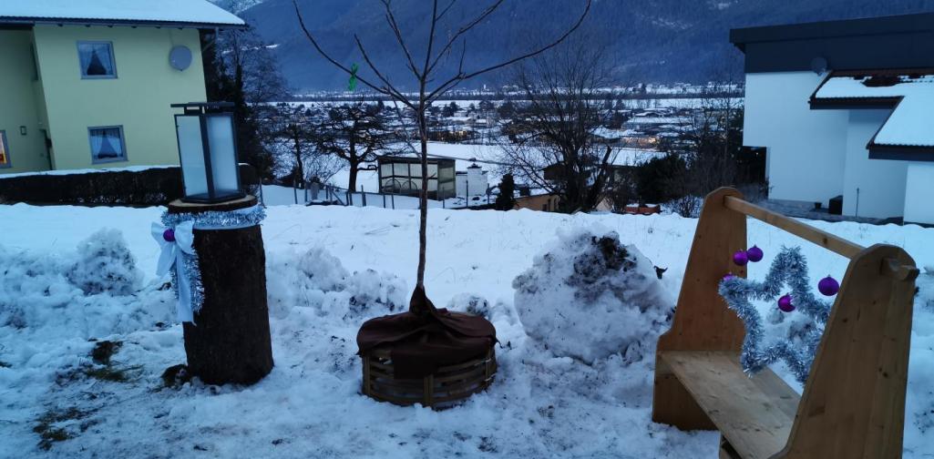 Verena Ein Platz mit Baum und Laterne und einer Bank, weihnachtlich dekoriert