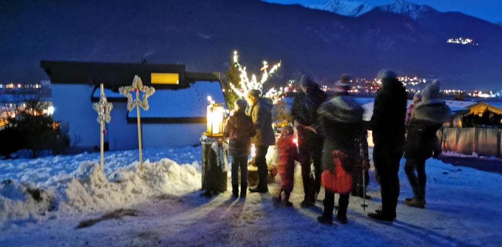 Verena Einige Menschen stehen vor der letzten Station und dem leuchtenden Baum
