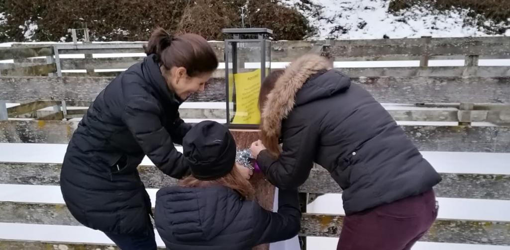 Verena Drei Pädagoginnen dekorieren einen Baumstamm