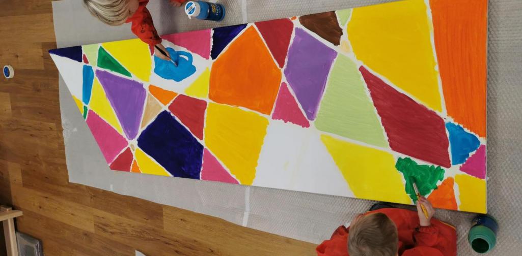 Verena Zwei Kinder arbeiten an dem großen Gemeinschaftsbild