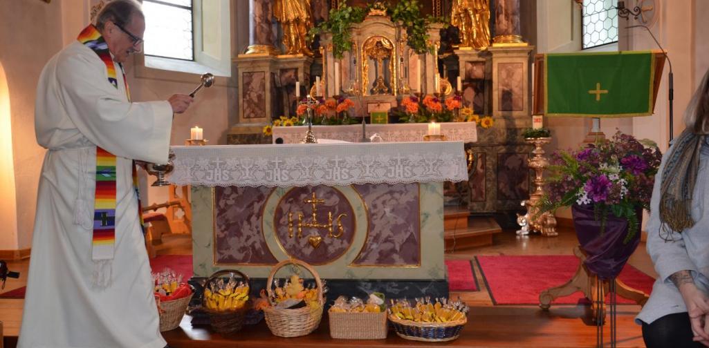 Der Pfarrer segnet die Körbe vor dem Altar