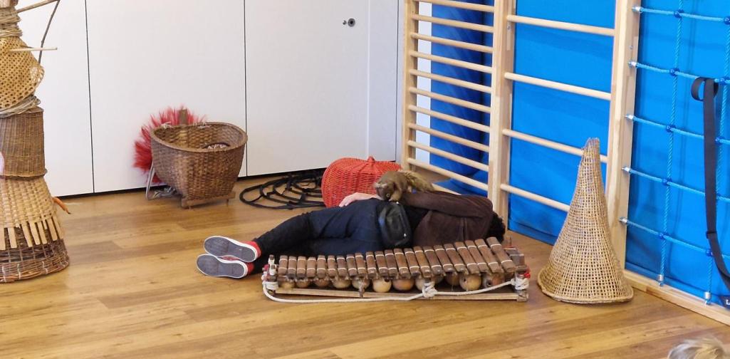 Verena Eder Der Künstler liegt am Boden und spielt mit der Eichhörnchen-Handpuppe