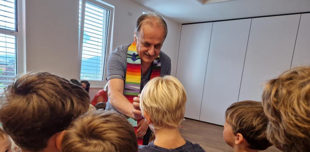 Verena Eder Der Pfarrer Josef Scheiring segnet die Kinder und macht ihnen ein Kreuz auf die Stirn