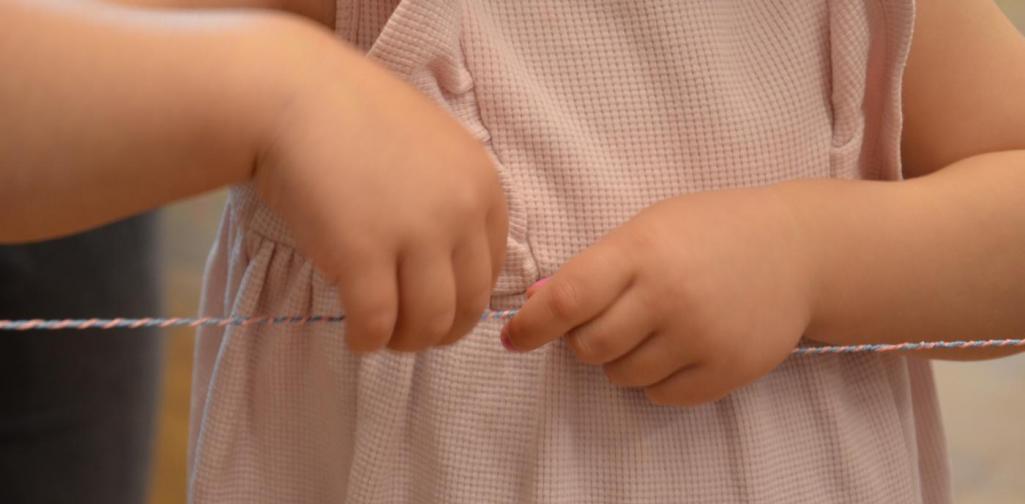 Barbara Baldauf Kinderhände die eine Garnschnur für den Vater dreht